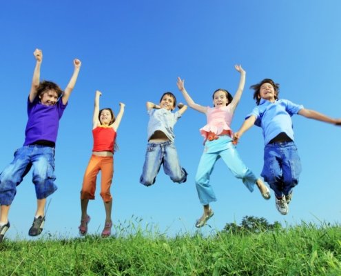 Kids jumping happily in the grass