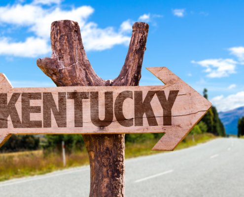 Sign on the side of the road with an arrow leading in the direction of Kentucky