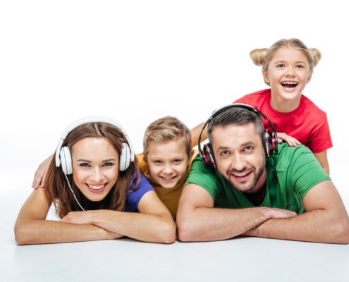 Family of four together, mom and dad both have headphones on