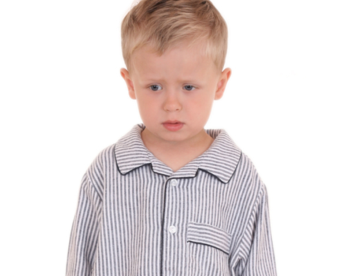 Little boy wearing pajamas and looking sad