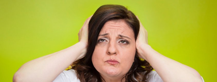 Woman looking frustrated holding her head